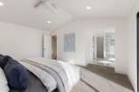 Experience modern luxury in this spacious bedroom featuring a vaulted ceiling and a sleek ceiling fan.