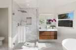Experience modern luxury in this stunning bathroom, featuring a spacious glass-enclosed shower with marble tile and a rainfall showerhead.