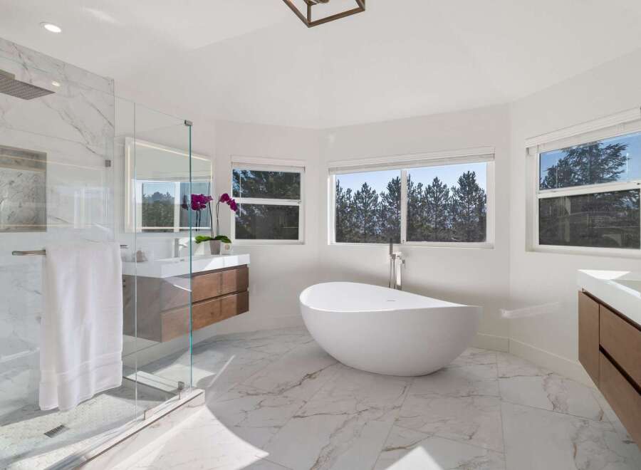 Experience luxury in this stunning master bathroom, featuring a freestanding soaking tub and a spacious walk-in shower with marble tile.