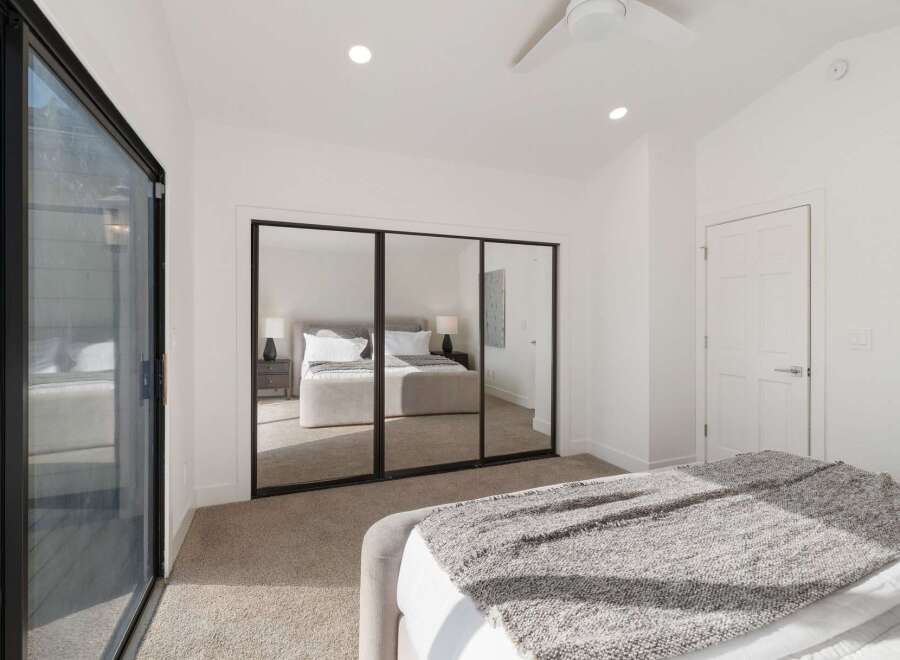 This spacious bedroom features a large mirrored closet, perfect for maximizing storage and creating an illusion of more space.