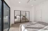 This spacious bedroom features a large mirrored closet, perfect for maximizing storage and creating an illusion of more space.