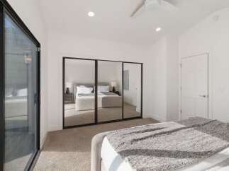 This spacious bedroom features a large mirrored closet, perfect for maximizing storage and creating an illusion of more space.