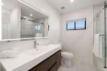 Experience modern luxury in this beautifully appointed bathroom, featuring a sleek vanity with a vessel sink and a stunning illuminated mirror.