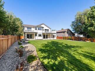 Experience luxurious outdoor living in this stunning backyard, featuring a sprawling green lawn perfect for recreation and relaxation.