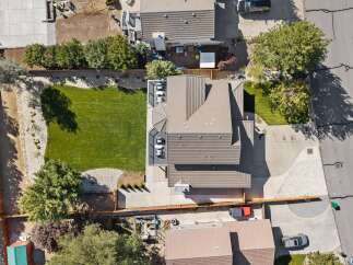 Discover this stunning aerial view of a modern home featuring a beautifully manicured lawn and a spacious backyard perfect for outdoor living.