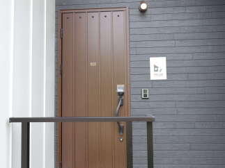 Discover modern living with this stylish entrance featuring a sleek brown door and contemporary grey siding.
