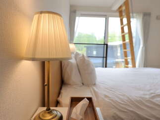 Experience comfort and style in this beautifully appointed bedroom, featuring a plush bed with crisp white linens and a bedside lamp casting a warm glow.