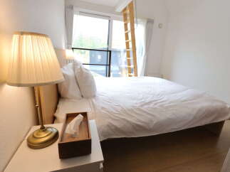 Experience comfort and style in this inviting bedroom, featuring a plush bed with crisp white linens and a convenient bedside table.