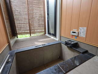 Experience ultimate relaxation in this private outdoor bathing area, featuring a deep soaking tub surrounded by natural wood and stone accents.