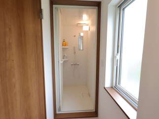 Step into a bright and modern bathroom featuring a clean, white shower stall with convenient shelving for toiletries.