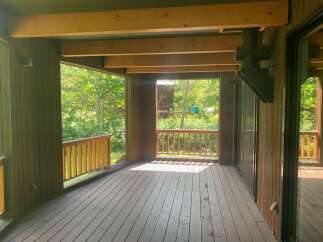 Enjoy the outdoors from this spacious covered deck, perfect for relaxing or entertaining.