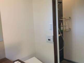 This modern bathroom features a sleek toilet and a separate shower enclosure with a rainfall showerhead.