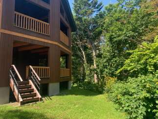 Experience the charm of this rustic wooden home nestled amidst lush greenery.