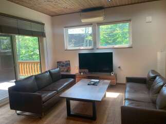 Experience modern living in this spacious living room featuring two plush leather sofas and a sleek coffee table.
