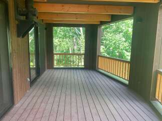 Enjoy the serene natural surroundings from this spacious wooden deck, perfect for outdoor living and entertaining.