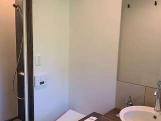 Experience modern comfort in this well-appointed bathroom, featuring a sleek toilet with integrated controls and a separate shower enclosure.