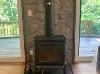 Cozy up by the modern wood-burning stove, a perfect centerpiece for this rustic living space.
