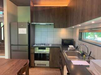 This modern kitchen features dark wood cabinetry and a sleek stainless steel refrigerator.