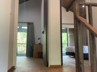 Step into this charming hallway featuring beautiful hardwood floors and a rustic wooden staircase.