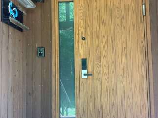 Discover this charming property featuring a modern wooden door with a sleek digital lock and a convenient side window for natural light.