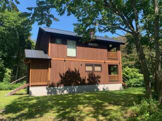 Discover this charming wooden house nestled amidst lush greenery, offering a serene retreat.