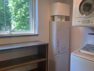 Discover a practical laundry space featuring a stacked washer and dryer, perfect for maximizing efficiency.