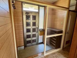 Step into this charming entryway featuring a classic wooden door with decorative glass panels, perfect for welcoming guests.