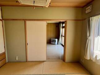Discover this charming room featuring traditional tatami flooring and a sliding shoji door, offering a serene and authentic Japanese aesthetic.