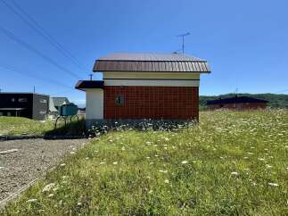 Discover this charming property featuring a unique building with a striking red tile facade and a modern brown metal roof.