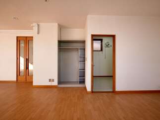 Discover this spacious room featuring a built-in closet with shelving and a hanging rod, perfect for storage.