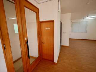 Discover this inviting space featuring a prominent wooden door with a glass panel, leading to a well-lit interior.