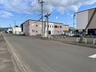Discover this charming property featuring a light pink multi-story building with white trim and multiple windows, perfect for residential or commercial use.