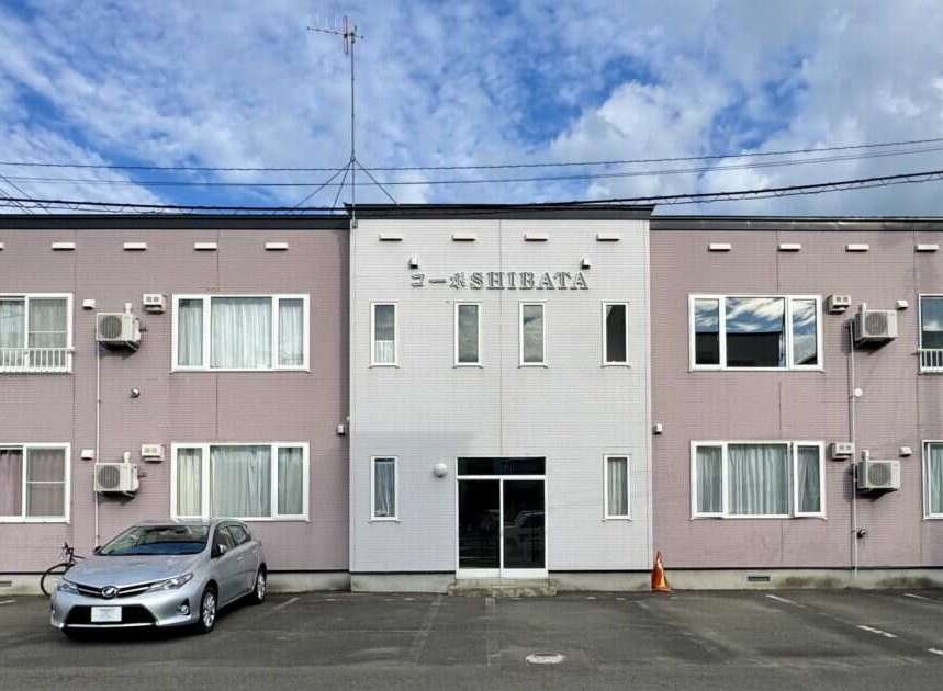 Discover modern living in this well-maintained apartment building, featuring a prominent 'SHIBATA' sign.