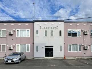 Discover modern living in this well-maintained apartment building, featuring a prominent 'SHIBATA' sign.