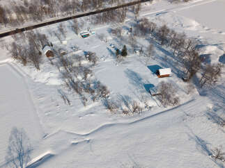 Discover this charming winter retreat featuring cozy cabins nestled amidst a serene snow-covered landscape.