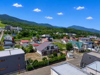 Discover this charming residential area nestled against a backdrop of lush green mountains.