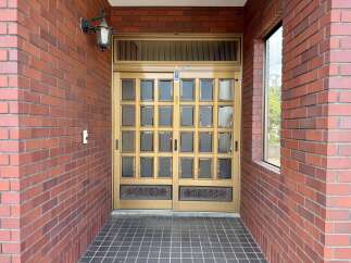 Step into this charming property featuring a classic brick exterior and elegant double doors with glass panels.