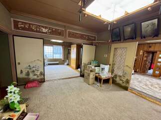 Discover the serene beauty of this traditional Japanese-style room, featuring elegant shoji screens with landscape paintings and intricate wooden carvings above.