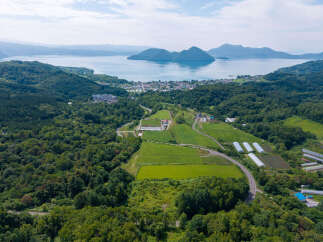 Discover this stunning aerial view of a property nestled amidst lush greenery, offering a serene escape.