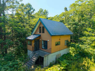 Nestled amidst lush greenery, this charming A-frame cabin offers a serene retreat.