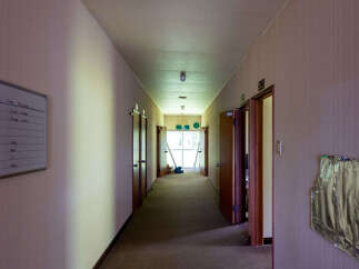 Explore this abandoned hallway, featuring multiple doors and a whiteboard with Japanese writing.