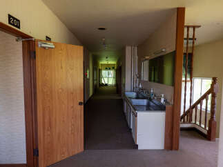 Explore this unique property featuring a long hallway with multiple doors, perfect for a multi-unit dwelling or a spacious private residence.