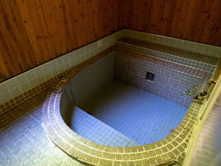 Experience ultimate relaxation in this traditional Japanese-style bathroom, featuring a deep soaking tub tiled in soothing blue.