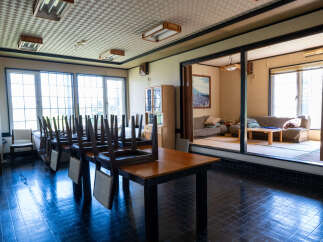 This spacious room features a large dining area with tables and chairs, perfect for gatherings.