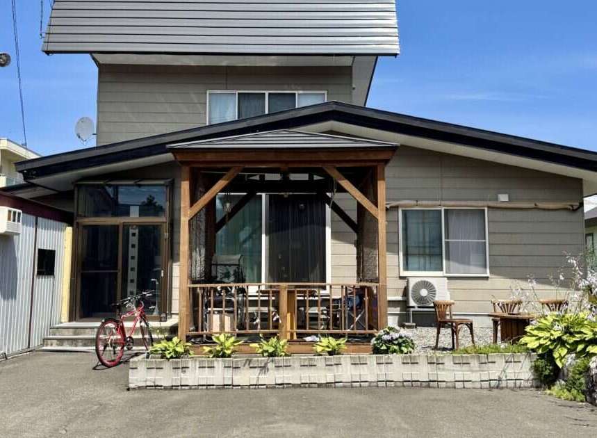 Discover this charming property featuring a welcoming covered porch with wooden beams, perfect for outdoor relaxation.