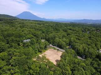 Discover this prime piece of land nestled amidst lush greenery, offering a serene escape with a majestic mountain backdrop.