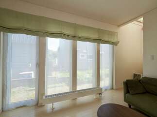 Experience natural light flooding into this spacious living area through expansive windows, creating a bright and airy atmosphere.