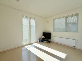 Bright and airy living space featuring large windows with blinds that allow ample natural light to flood the room.