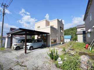 Discover this charming property featuring a covered carport with two compact cars, perfect for protecting your vehicles from the elements.