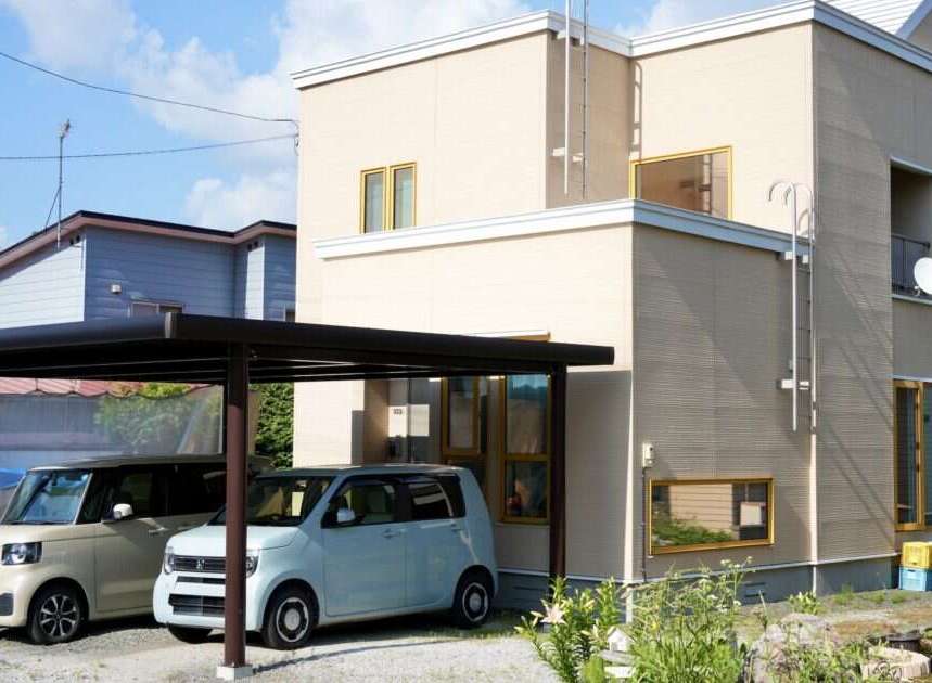 Discover this charming property featuring a modern two-story house with a light beige exterior and a sleek black carport.